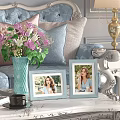Light Blue Photo Frames with Women Photos Near Vase with Flowers and Gold Lamp