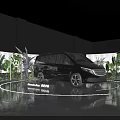 Black MPV Car Showcase On Circular Platform With Green Plants And Screens