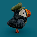 Knitted Puffin Doll With Green Hat Orange Beak Blue And White Body On Blue Background
