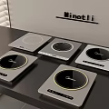 Modern Kitchen Appliances Showcasing Multiple Induction Cooktops On Black Countertop With Gray Wall