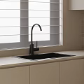Black Kitchen Sink With Modern Faucet On Light Countertop And Beige Cabinets