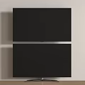 Sleek Black Modern Television With Metal Stand Against Light Colored Wall