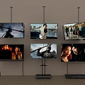 Multiple TVs Wall Mounted And On Stands Showing Different Video Scenes