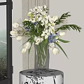 Clear Glass Vase With White Lilies Blue Tulips And Green Leaves On Wooden Table