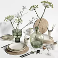 White Ceramic Dinnerware Set With Plates Bowls Green Glass Vases And Decorative Branches On Tabletop