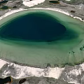 Garden Landscape Showcasing Circular Pond With Deep Dark Center Light Green Water And White Shoreline