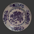 Traditional Blue and White Ceramic Plate Decoration with Intricate Floral Fruit Patterns Against Dark Background