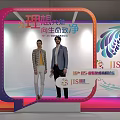 Contemporary Exhibition Hall With People Moving Around Decorative Flower Booths And Display Panels