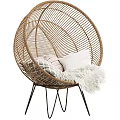 Rattan Round Outdoor Chair With Soft Pillows And Faux Fur Throw On Metal Stand