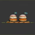 Delicious Swedish Desserts with Flags on Wooden Tray Topped with Powdered Sugar and Green Crumbs