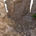 Natural Rocky Scene With Tall Stone Pillars Scattered Rubble And Small Green Plants