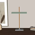 Modern Minimalist Desk Lamp With Wooden Pole Silver Base Green Shade And Open Book On Wooden Table
