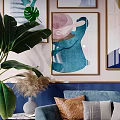 Blue Two Seater Sofa With Colorful Throw Pillows And Blanket Against Decorative Wall Art