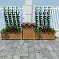 Decorative Garden Planters With Tall Green Plants Pink Flowers Against White Fence Stone Pavement