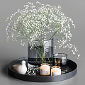Transparent Vase With White Baby's Breath Flowers On Black Tray With Candles And Bird Ornament