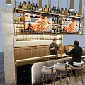 Modern Bar Interior With Golden Counter Wine Bottles Screens And High Stools
