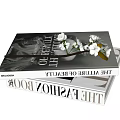 Stacked Art And Beauty Books With White Flowers And Green Leaves