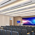 Modern Conference Room Interior With Rows of Gray Chairs Podium Large Screen and Ceiling Lights