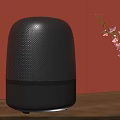 Black Wireless Speaker on Wooden Table with Orange Wall and Black Vase with Pink Flowers