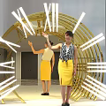 Giant Clock Art Installation With Illuminated Roman Numerals And People Interacting
