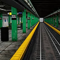 Modern Times Square Subway Station Platform With Green Pillars Yellow Safety Lines And Train Tracks