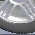 Car Tire with Silver Alloy Wheel and Tread Pattern on Light Blue Background