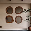 Four Round Mirrors With Wooden Frames Hanging On Beige Wall Beside Green Plant And Bowl