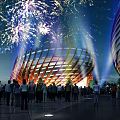 Stunning Night Urban Landscape With Fireworks Modern Curved Building And Crowd Gathering