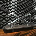 Crossed Swords with Golden Decorations on Black Geometric Wall Illuminated by Lights and Wooden Base
