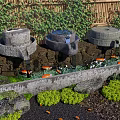 Stone Water Features In Garden With Bamboo Fence Orange Koi Fish And Aquatic Plants