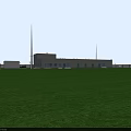 Industrial Factory Building With Gray Exterior Multiple Windows Doorways Green Grass Field And Tall Tower