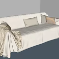 Beige Slipcovered Sectional Sofa With Cushions Blanket And Blue Rug On Wooden Floor