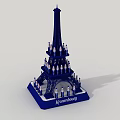 Kinderburg Themed Eiffel Tower Model With Small Figures On Tower Structure Standing On Blue Base