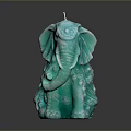 Turquoise Elephant Shaped Candle With Intricate Decorative Details On Black Background
