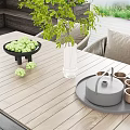 Outdoor Wicker Chairs With Wooden Table On Patio By Lake And Green Plants