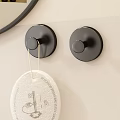 Black Circular Wall Hooks On Light Colored Wall With Hanging Tag Item