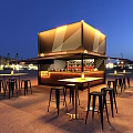 Illuminated Container Style Bar at Night with High Top Tables Bar Stools and Harbor Backdrop