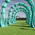 Green Fabric Event Entrance Arch With Multiple Arches In Outdoor Grass Field