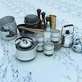Stainless Steel Dinnerware Set With Assorted Cooking Utensils Teapot And Cups On Marble Countertop