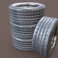 Car Tires Stacked with One Leaning Tire Featuring Metal Wheel Rim