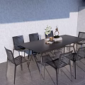 Stylish Black Outdoor Table With Woven Metal Chairs And Decorative Items