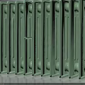 Green Cast Iron Radiator With Red Valves And Multiple Heat Fins On Dark Background
