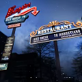 Illuminated Ferrari And Restaurant Signs With Dick Orso 70 In Night View
