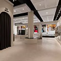 Clothing Store Exterior with Arched Entrance Window Display Mannequins White Building Street and Green Trees
