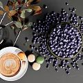 Fresh Blueberries in Bowl on Dark Surface with Coffee Cup Macarons and Leafy Vase