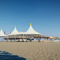 Waterfront Landscape With White Tents Yellow Spires And Sandy Beach Under Blue Sky