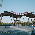 Large Wooden Arched Entrance Gate with Vehicles Pedestrians and Trees Under Blue Sky