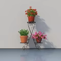 Potted Plants On Black Metal Three Tier Stand With Red Pink Flowers And Green Foliage