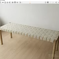 Light Colored Bench With Woven Surface And Wooden Legs On Wooden Floor Indoor