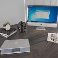 Desktop Setup With iMac Laptop Headphones Charger Books And Alarm Clock